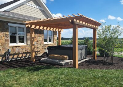 a backyard with a wooden deck and a stone building