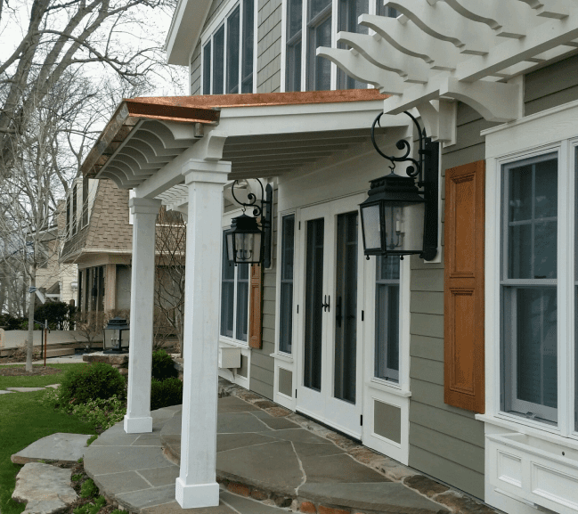 The porch features a white railing and a black light fixture, adding a touch of elegance to the home