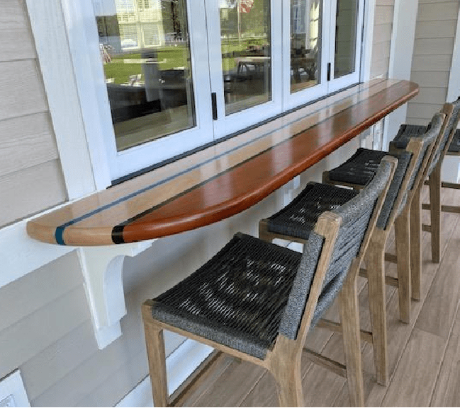 a dining area with a long wooden bench placed against a wall